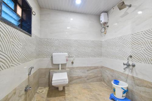 ein weißes Bad mit einem WC und einer Badewanne in der Unterkunft AMAZZ 4BHK VILLA LONAVALA in Lonavla