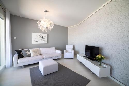 uma sala de estar com um sofá e uma televisão em Meritähti Apartments by Hiekka Booking em Kalajoki