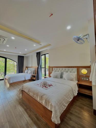 a large bedroom with two beds and a large window at SK BOUTIQUE HOTEL in Phú Quốc