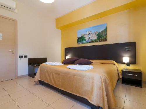 a bedroom with a large bed with two towels on it at Al Molì Affittacamere in Cagliari