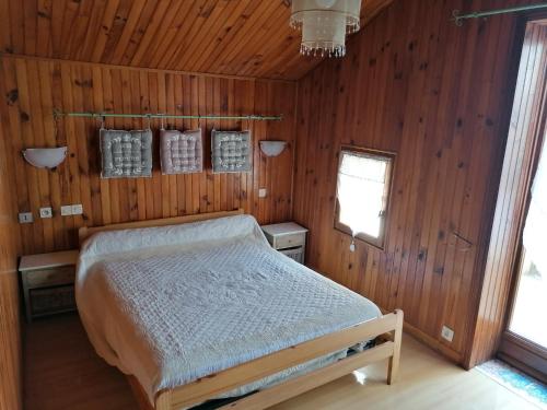 Heugas的住宿－Domaine Manos，木制客房内的一间卧室,配有一张床