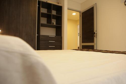 1 dormitorio con cama y armario en Nubes Apart Hotel en Salta