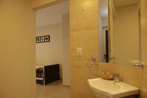 y baño con lavabo y espejo. en Nubes Apart Hotel en Salta
