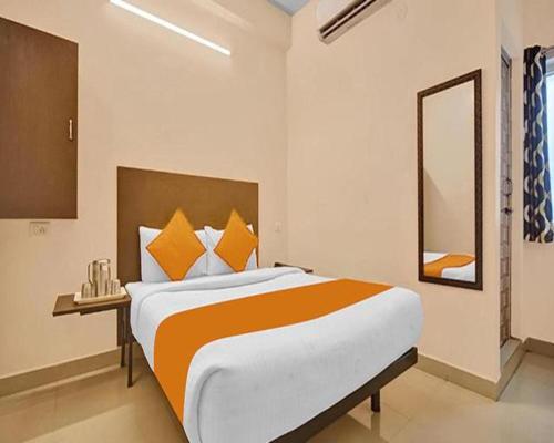 a bedroom with a large bed and a mirror at FabExpress Joel Inn in Chennai