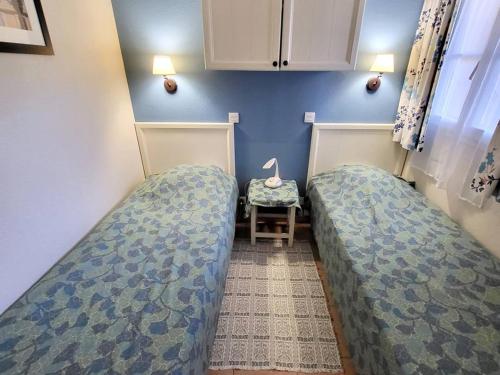 une petite chambre avec deux lits et une chaise dans l'établissement T2 avec piscine, parking privé à 200m des plages et commerces - FR-1-316-237, à Six-Fours-les-Plages