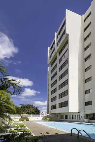 a large white building with a swimming pool in front of it at Radisson Hotel Santo Domingo in Santo Domingo