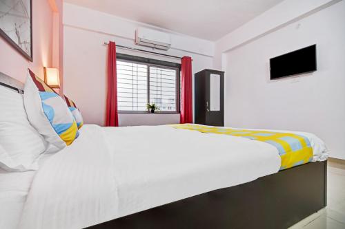 a bedroom with a large white bed and a window at OYO Home Designer Stay Hinjewadi in Hinjewadi