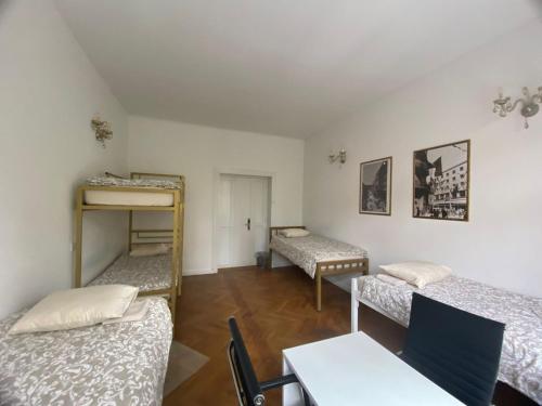 Pokój z 3 łóżkami piętrowymi i stołem w obiekcie Rooms Miklošičeva w Lublanie