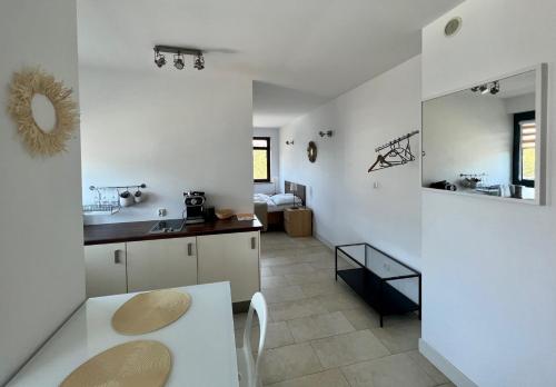 a white kitchen with a sink and a table at Bursztynowa 16 Hel in Hel