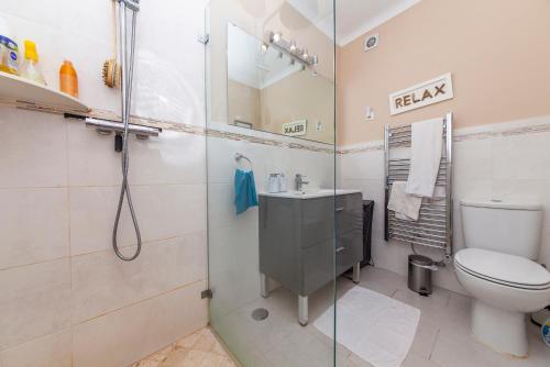 a bathroom with a shower and a toilet and a sink at Porto Dona Maria Apartment in Luz
