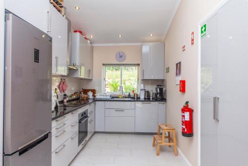 a kitchen with white cabinets and a window at Porto Dona Maria Apartment in Luz