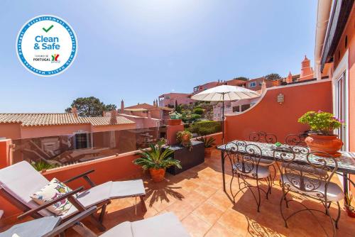 a patio with a table and chairs and a building at Porto Dona Maria Apartment in Luz