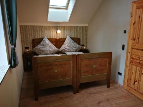ein Schlafzimmer mit einem Holzbett mit Kissen darauf in der Unterkunft Ferien in der alten Scheune in Kurort Altenberg