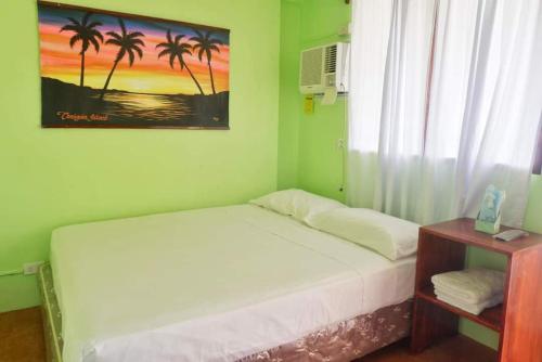 a bedroom with a bed and a window with palm trees at Puesta del sol Beach Bungalows and Restobar in Abu