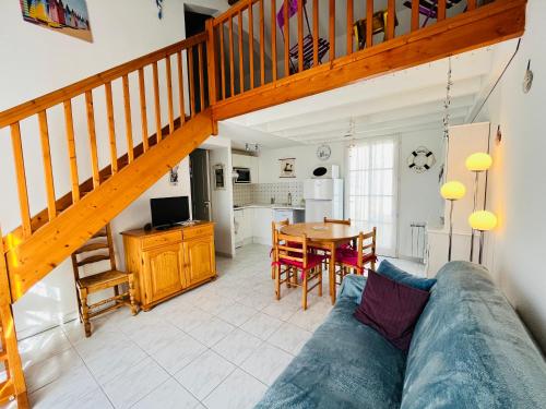 un salon avec un canapé et un escalier en bois dans l'établissement Maison du lac, golf et océan à 100m, à Saint-Jean-de-Monts