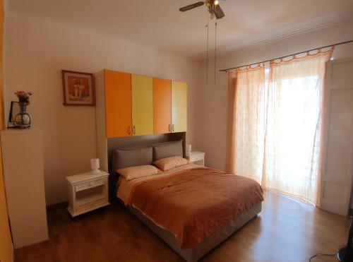Schlafzimmer mit einem Bett mit bunten Schränken und einem Fenster in der Unterkunft Sweet Home Bari in Bari