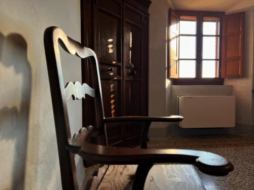 a wooden chair in a room with a window at Monastero Sant'Anna in Camprena in Pienza