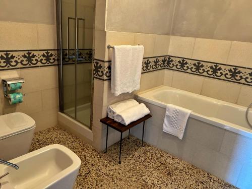 a bathroom with a tub and a toilet and a sink at Monastero Sant'Anna in Camprena in Pienza