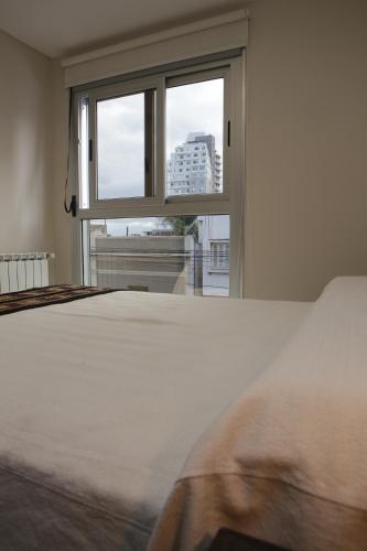 a bedroom with a bed and a window at Departamentos Nubes - Salta Capital in Salta