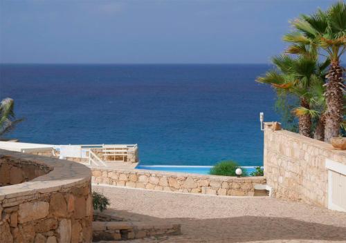 a swimming pool with the ocean in the background at Villa Lagosta Stella Maris Exclusive in Vila do Maio