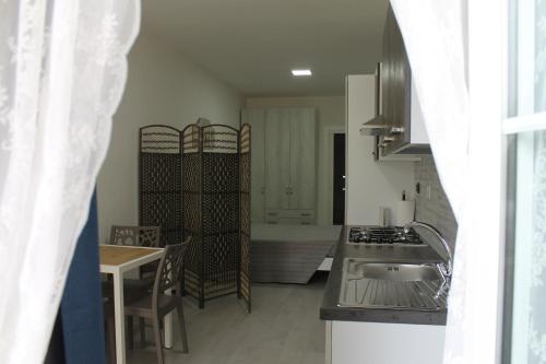 een keuken met een wastafel en een tafel in een kamer bij Casa da Tonia Peschici in Peschici