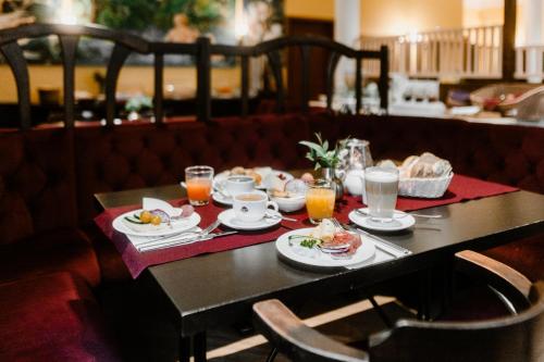 a table with plates of food and drinks on it at Hotelpark Bodetal mit Ferienwohnungen in Thale