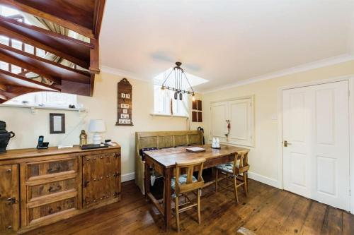 cocina con mesa de madera y comedor en Chapel Cottage en Canterbury