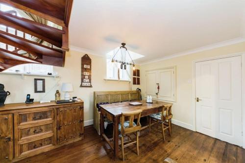 a kitchen with a wooden table and a dining room at Chapel Cottage in Canterbury