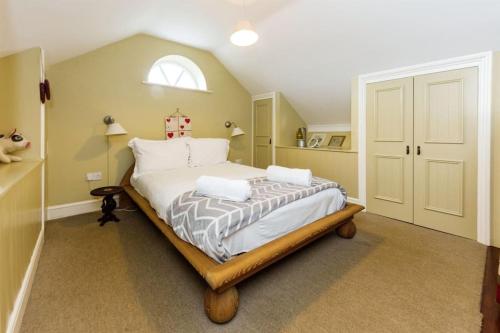 Schlafzimmer mit einem großen Bett und einem Fenster in der Unterkunft Chapel Cottage in Canterbury