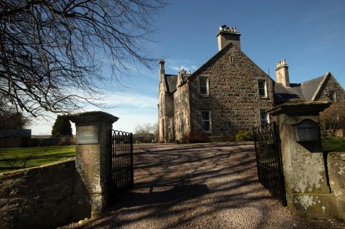 an old house with a gate in front of it at Cardhu Country House in Aberlour