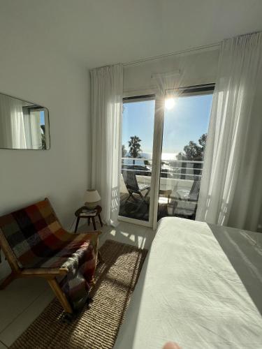 sypialnia z łóżkiem i krzesłem oraz balkon w obiekcie Vue mer Agay w mieście Anthéor