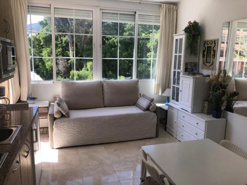 sala de estar con sofá y algunas ventanas en Carihuela Sun Beach, en Torremolinos