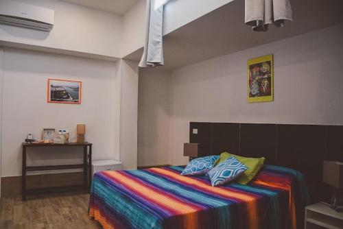 a bedroom with a bed with a colorful blanket at L'ANFORA DELLE MURELLE in Torre di Montalto