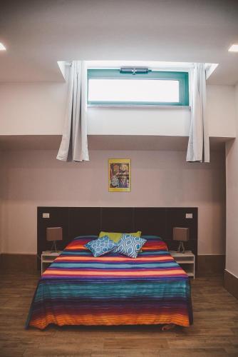 a bedroom with a bed with a window above it at L'ANFORA DELLE MURELLE in Torre di Montalto