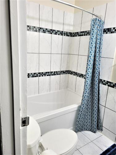 a bathroom with a white tub and a toilet at Cozy 4 bedroom townhouse - peaceful feel of home in Winnipeg