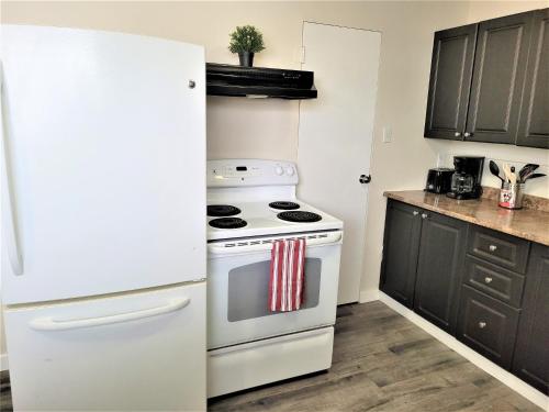 uma cozinha com um fogão branco e um frigorífico em Cozy 4 bedroom townhouse - peaceful feel of home em Winnipeg