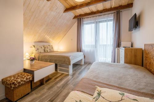 een slaapkamer met 2 bedden en een raam bij Sara in Karpacz