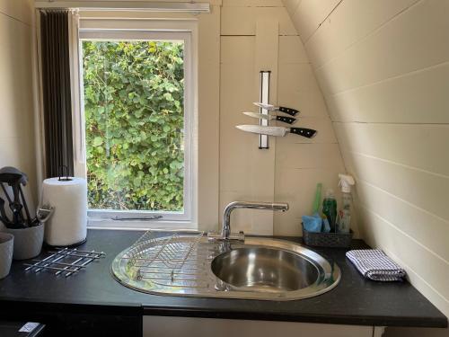 fregadero en una cocina con ventana en Glamping Pod with ensuite WC Near Kingsbridge & Salcombe en Kingsbridge