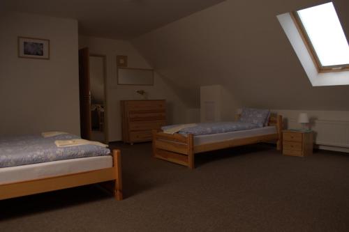 a attic room with two beds and a window at Hostinec vo Višňovom in Stará Turá