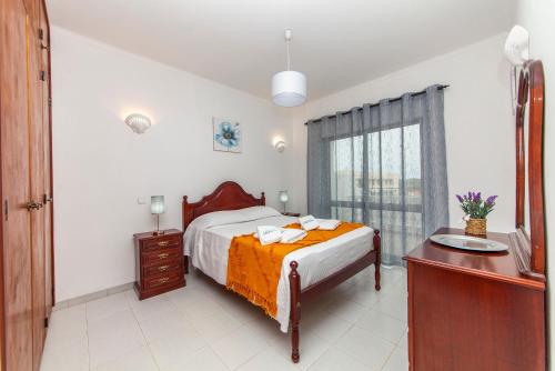 ラゴスにあるCarrob Street Houseのベッドと机と窓のある寝室