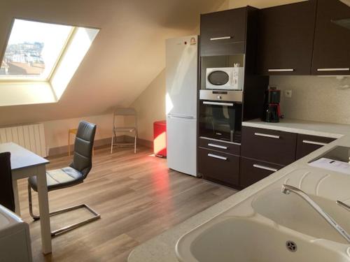 a kitchen with a sink and a refrigerator and a microwave at Les Afforêts Le Loft in La Roche-sur-Foron