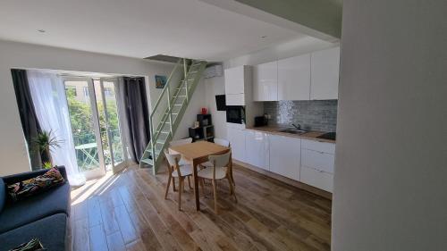 eine Küche mit einem Tisch und eine Treppe in einem Zimmer in der Unterkunft Appartement Premium in Beaulieu-sur-Mer
