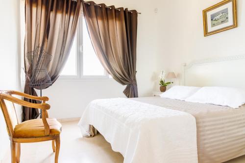 een slaapkamer met een bed, een stoel en een raam bij Sea view apartment between Nice and Monaco - 1 in Villefranche-sur-Mer