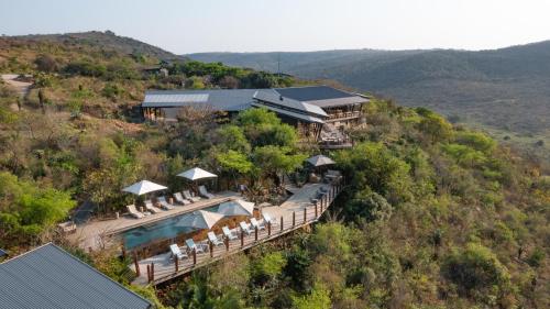 an aerial view of a house on a hill with a pool at Rhino Ridge Safari Lodge in KwaNompondo