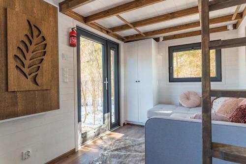 Habitación pequeña con cama y ventana en Tiny House w Camp Gorący Potok en Szaflary