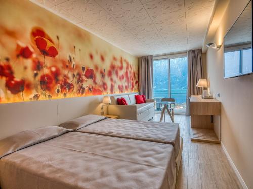 a hotel room with a bed and a couch at Hotel Cristina in Limone sul Garda