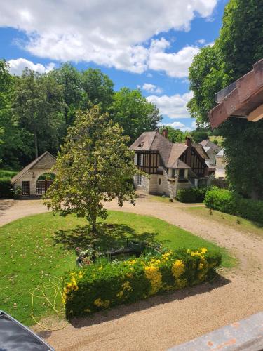 a house with a tree in the middle of a yard at LA MARCELINE in Saint-Aignan