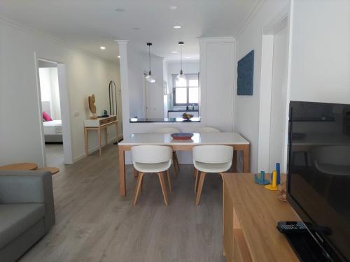 Una cocina y una sala de estar con mesa y sillas. en Apartamento Salty Tides, en Altura