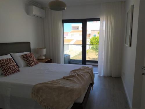 Un dormitorio con una cama grande y una ventana grande. en Apartamento Salty Tides, en Altura