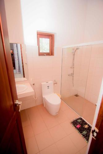 a bathroom with a toilet and a shower and a sink at Airport Villa in Katunayake